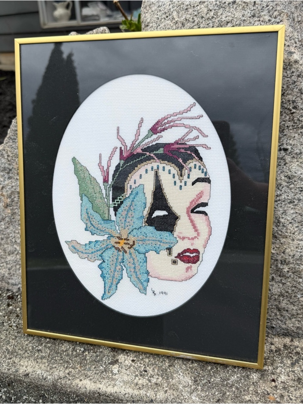 Fantasy mask embroidered cross stitch art by Jeanne Christine. Framed wall art